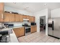 Functional kitchen with stainless steel appliances and wood cabinets, perfect for cooking at 9133 W Virginia Ave, Phoenix, AZ 85037