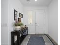 Bright entryway with a white front door, stylish console table, and a striped rug at 9238 W Roma Ave, Phoenix, AZ 85037