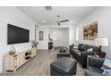 Open-concept living room with wood tile floors, modern decor, and plenty of light at 9238 W Roma Ave, Phoenix, AZ 85037