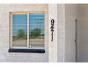 Close-up showing the house number next to a window with blinds for privacy and light control at 9471 W Magnum Dr, Arizona City, AZ 85123