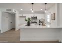 Modern kitchen featuring white cabinetry, stainless steel appliances, and a spacious quartz countertop island at 1051 E Millett Ave, Mesa, AZ 85204