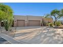 Desert home exterior featuring a wide driveway, two-car garage and desert landscaping at 11299 E Greythorn Dr, Scottsdale, AZ 85262