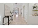 Hallway leading to a living room with tiled floor, neutral decor, and natural light at 11299 E Greythorn Dr, Scottsdale, AZ 85262