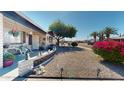 Inviting front yard featuring a decorative rock garden, mature tree, and charming penguin statues at 1710 W 13Th Ave, Apache Junction, AZ 85120