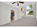 Neutral living room with high ceilings, a ceiling fan, carpet, and large windows at 2605 W Darrel Rd, Phoenix, AZ 85041