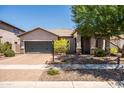 Well-maintained single-story home featuring a desert landscape, a two-car garage, and a covered entryway at 3022 E Santa Fe Ln, Gilbert, AZ 85297