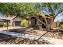 Single-story home featuring a desert landscape, a two-car garage, and a covered entryway with stone pillars at 3022 E Santa Fe Ln, Gilbert, AZ 85297