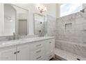 Bright bathroom featuring a marble vanity with double sinks and a glass-enclosed shower with marble tiling at 3940 E Heather Ct, Gilbert, AZ 85234