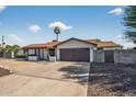 Inviting single-story residence with a two-car garage, desert landscaping, and a covered porch at 5101 E Paradise Dr, Scottsdale, AZ 85254