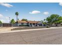 Single-story home featuring desert landscaping, a two-car garage, and privacy fence for a secluded outdoor space at 5101 E Paradise Dr, Scottsdale, AZ 85254