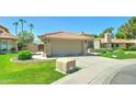 Single-Gathering home featuring manicured lawn with mature trees, desert landscaping, and an attached garage at 5431 E Piping Rock Rd, Scottsdale, AZ 85254
