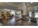 Open floor plan with dark wood flooring, a step-down living room, dining room, and partial view of the kitchen at 5431 E Piping Rock Rd, Scottsdale, AZ 85254