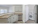 The kitchen features stainless steel appliances and light cabinets with a laundry closet at 600 W Grove Pkwy # 2188, Tempe, AZ 85283