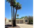 Beige stucco home featuring a two-car garage, palm trees, desert landscaping, and a concrete driveway at 632 W Fordham Dr, Tempe, AZ 85283