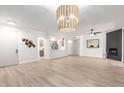 Spacious living room with wood-look tile floors, modern lighting fixture, and an inviting open-concept layout at 955 E Knox Rd # 126, Chandler, AZ 85225