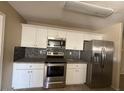 Modern kitchen featuring stainless steel appliances, granite countertops, and ample white cabinetry at 990 E Desert Rose Trl, San Tan Valley, AZ 85143