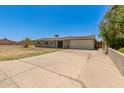 Single-story home with solar panels, light-colored siding and extended driveway at 1676 W Sequoia Dr, Phoenix, AZ 85027