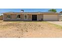Single-story home with solar panels, light-colored siding and desert landscaping at 1676 W Sequoia Dr, Phoenix, AZ 85027