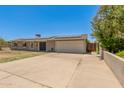 Single-story home with solar panels, light-colored siding and extended driveway at 1676 W Sequoia Dr, Phoenix, AZ 85027