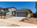 Charming single-story home with gray trim, a gray garage door, and desert landscaping at 17032 W Cavedale Dr, Surprise, AZ 85387