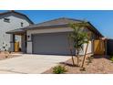 Charming single-story home with gray trim, a gray garage door, and desert landscaping at 17032 W Cavedale Dr, Surprise, AZ 85387