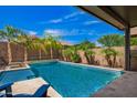 Relaxing backyard pool area with pristine water, lush landscaping, and patio area for lounging and entertaining at 18334 W Marshall Ln, Surprise, AZ 85388