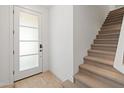 Bright entryway features a tiled floor, white trim door with glass, and a carpeted staircase at 2121 W Sonoran Desert Dr # 14, Phoenix, AZ 85085