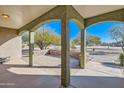 Spacious covered back porch with arched supports, perfect for outdoor relaxation at 2602 S 226Th Dr, Buckeye, AZ 85326