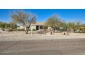 Single story home featuring desert landscaping and mature trees on a large lot at 2602 S 226Th Dr, Buckeye, AZ 85326