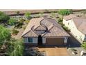Aerial view of a desert home showcasing its well-maintained tile roof and desert landscaping at 26774 W Firehawk Dr, Buckeye, AZ 85396