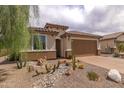 Beautiful home with desert landscaping, featuring gravel, cacti, and river rock accents at 26774 W Firehawk Dr, Buckeye, AZ 85396