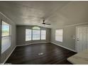 Bright living room featuring neutral walls, sleek wood floors, ceiling fan, and plentiful natural light at 318 N Pinal Dr, Apache Junction, AZ 85120