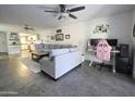 Spacious living room with a comfortable gray sofa, adjacent to an organized workspace with a pink gaming chair at 4050 E Cactus Rd # 107, Phoenix, AZ 85032