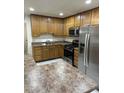 Traditional kitchen with wooden cabinets, stainless steel appliances, and laminate counters at 4502 N 50Th Ave, Phoenix, AZ 85031