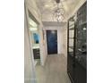 Stylish entryway featuring modern light fixture, display cabinet, and access to the bathroom at 7120 E Kierland Blvd # 404, Scottsdale, AZ 85254