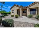 Single-story home featuring desert landscaping, a tiled roof, and a curved walkway leading to the front door at 7575 E Indian Bend Rd # 1005, Scottsdale, AZ 85250