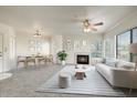 Bright living room with a fireplace, a ceiling fan, large windows, and an adjacent dining area at 7575 E Indian Bend Rd # 1005, Scottsdale, AZ 85250
