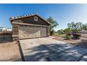 Two car garage with a wide driveway and desert landscaping in a quiet residential neighborhood at 8415 W Coolidge St, Phoenix, AZ 85037