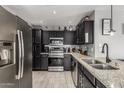 Well-equipped kitchen with stainless steel appliances, dark cabinetry, and granite countertops at 8415 W Coolidge St, Phoenix, AZ 85037