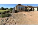 New home under construction with a partial roof, wood framework and dirt yard at 11410 E Utah Ave, Mesa, AZ 85212