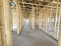 Unfinished interior showcasing the bare framework and concrete flooring in a new construction home at 11410 E Utah Ave, Mesa, AZ 85212