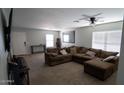Spacious living room featuring neutral walls and carpet, a ceiling fan, and lots of natural light at 11601 W Bloomfield Rd, El Mirage, AZ 85335