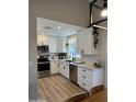 Modern kitchen features white cabinets, stainless steel appliances, and sleek countertops, creating a stylish cooking space at 1319 E Piute Ave, Phoenix, AZ 85024
