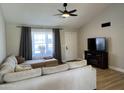 Cozy living room features a sectional sofa, ceiling fan, and large window, perfect for relaxation and entertainment at 1319 E Piute Ave, Phoenix, AZ 85024