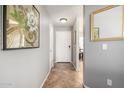 Inviting hallway with neutral paint, tile flooring, and decorative art leading into the rest of the home at 13864 W Ironwood St, Surprise, AZ 85374
