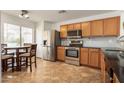 Well-lit kitchen with stainless steel appliances, wood cabinets and a cozy breakfast nook at 13864 W Ironwood St, Surprise, AZ 85374