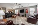 Spacious living room featuring a ceiling fan, plush carpet, and comfortable seating, great for relaxing at 13864 W Ironwood St, Surprise, AZ 85374