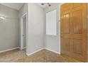 Neutral entryway with tile floors, a chandelier, and a wood door at 14621 W Catalina Dr, Goodyear, AZ 85395