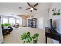 Bright and airy living room boasts neutral paint, plush carpeting, and abundant natural light from large windows at 15537 W Port Royale Ln, Surprise, AZ 85379