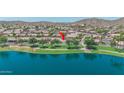 Expansive lakefront property showcasing lush green spaces, mature trees, and serene water views at 18088 W San Alejandro Dr, Goodyear, AZ 85338